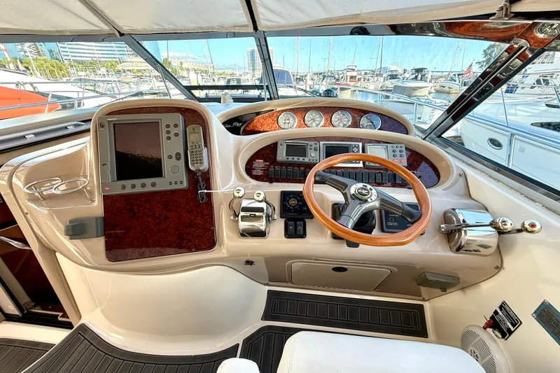 Slide: The Image of Helm of 2003 Sea Ray 380 Sundancer with wood accents and modern navigation equipment. - 13