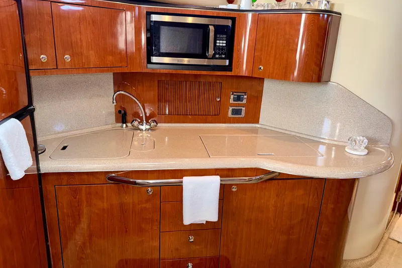 Slide: The Image of 2003 Sea Ray 380 Sundancer galley with wood cabinetry, sink, and microwave. - 20