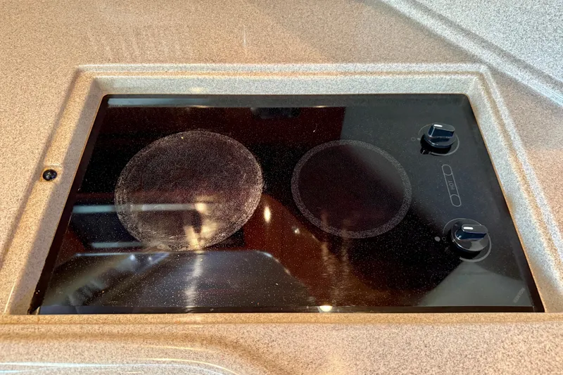 Slide: The Image of Stovetop on 2003 Sea Ray 380 Sundancer yacht, featuring two burners and control knobs. - 22