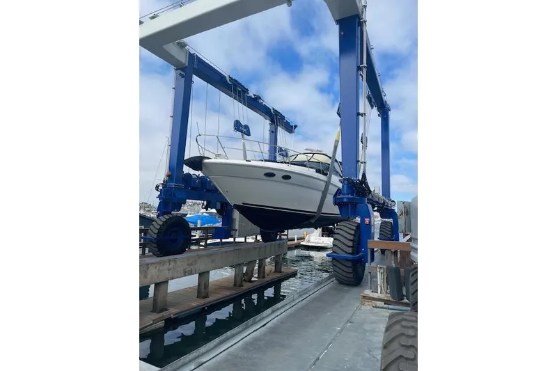 Slide: The Image of 2003 Sea Ray 380 Sundancer yacht lifted by a boat hoist at a marina. - 46