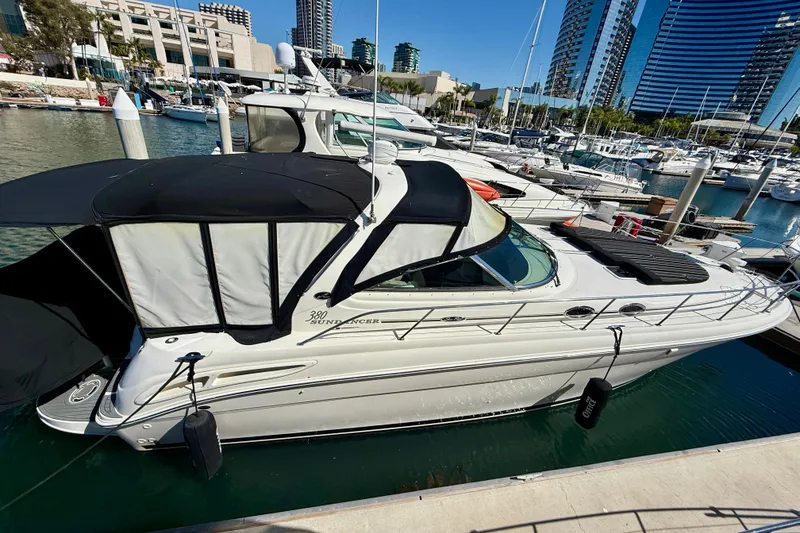 Slide: The Image of 2003 Sea Ray 380 Sundancer yacht docked in a marina with cityscape background. - 6