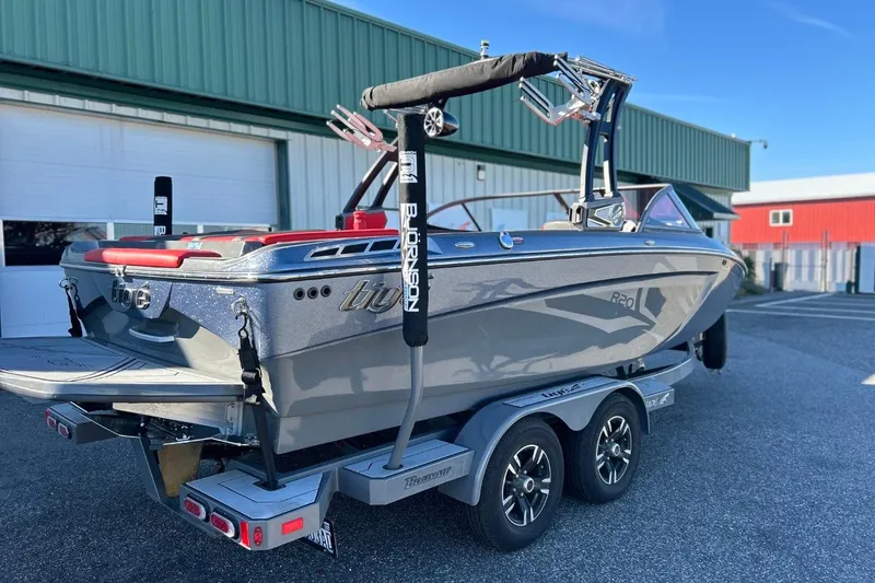 Slide: The Image of 2018 Tigé R20 boat on trailer, parked outside a green building. - 14