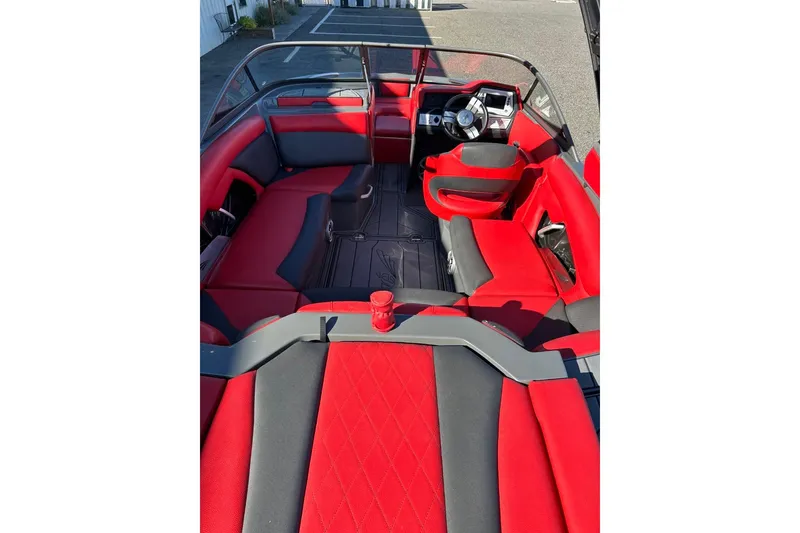 Slide: The Image of 2018 Tigé R20 boat interior with red and gray seating, steering wheel, and dashboard. - 17