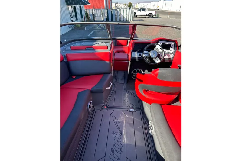 Slide: The Image of 2018 Tigé R20 boat interior with red and black seating, steering wheel, and dashboard. - 20