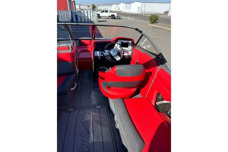 Slide: The Image of 2018 Tigé R20 boat interior with red and black seating, steering wheel, and dashboard. - 21