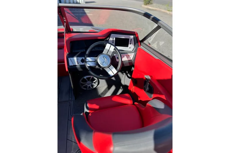 Slide: The Image of 2018 Tigé R20 boat interior with red and black seating, steering wheel, and dashboard. - 23