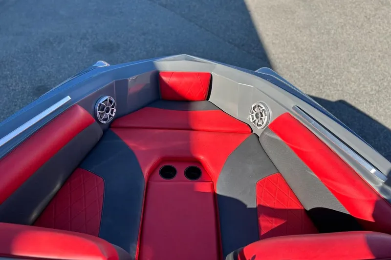 Slide: The Image of 2018 Tigé R20 boat interior with red and gray seating, cup holders, and speakers. - 24