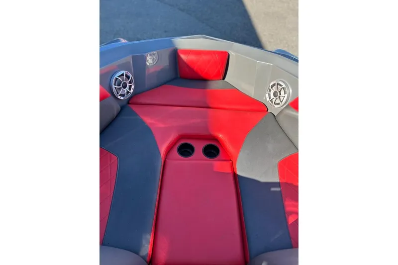 Slide: The Image of 2018 Tigé R20 boat interior with red and gray seating, cup holders, and speakers. - 26