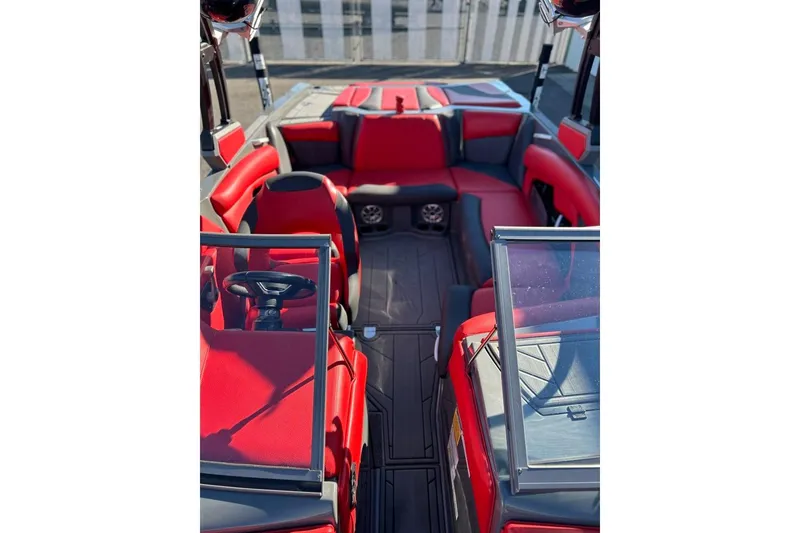 Slide: The Image of 2018 Tigé R20 boat interior with red and gray seating, steering wheel, and open windshield. - 28