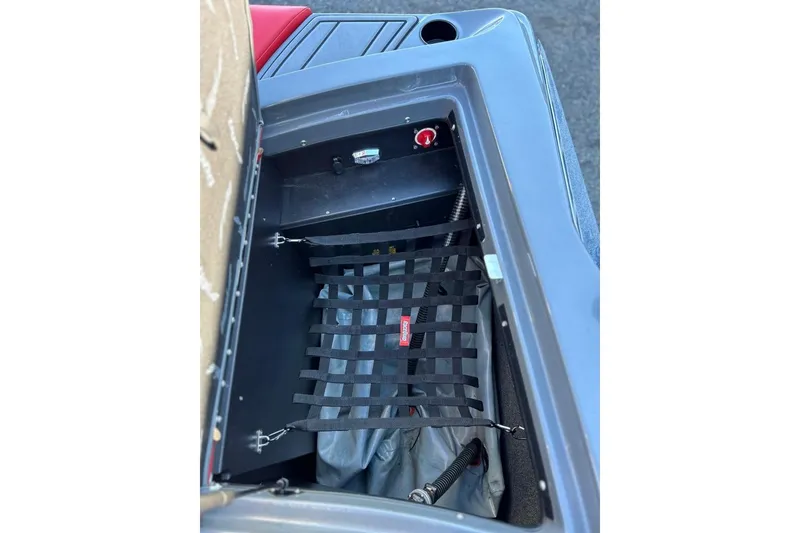 Slide: The Image of Storage compartment of a 2018 Tigé R20 boat with netting and red switch. - 32