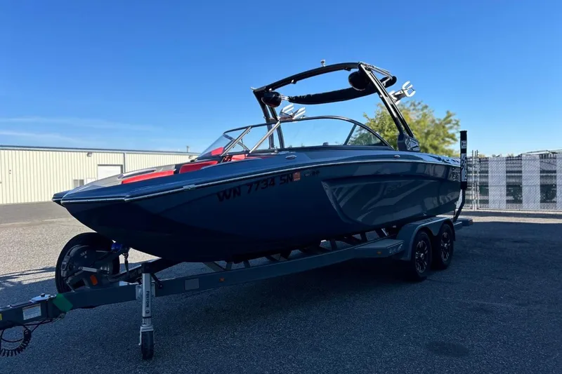 Slide: The Image of 2018 Tigé R20 boat on trailer, parked outdoors under clear blue sky. - 5