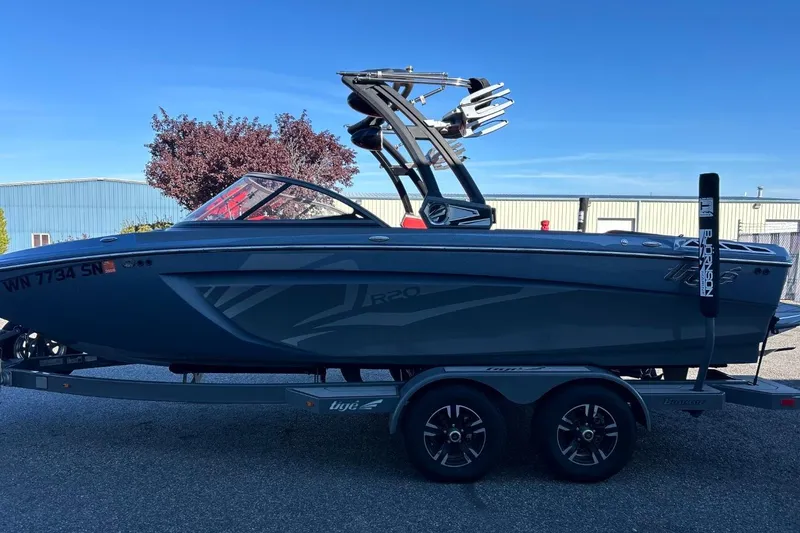 Slide: The Image of 2018 Tigé R20 boat on trailer, sleek design, blue exterior, parked outdoors. - 6