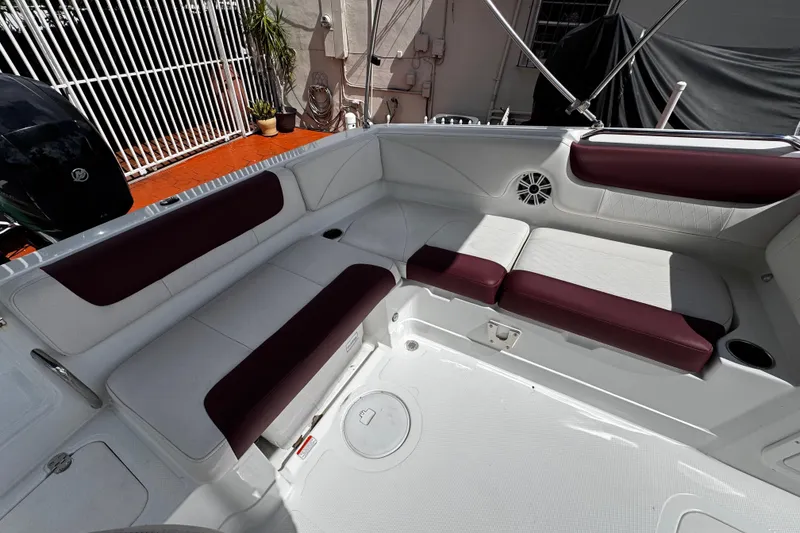 Slide: The Image of 2017 Tahoe 2150 boat interior with white and maroon seating, outdoor setting. - 12