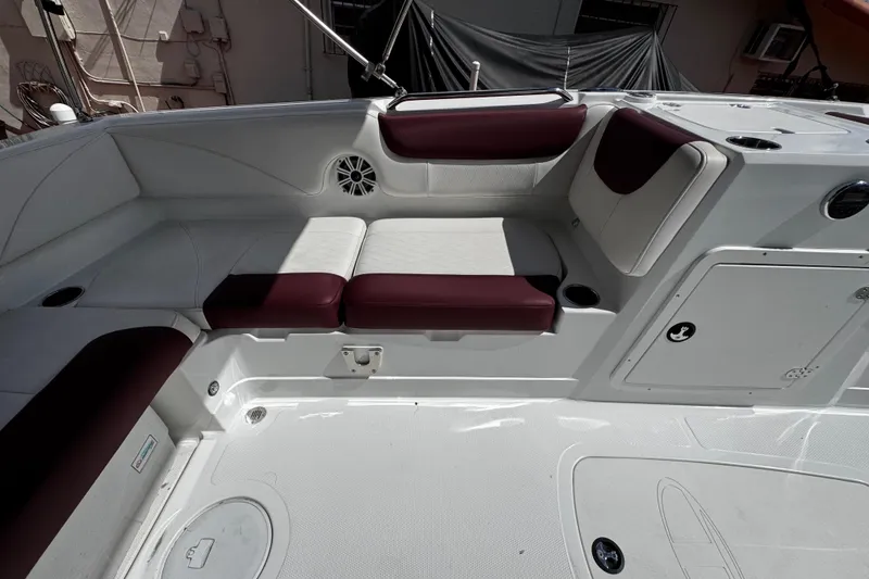 Slide: The Image of 2017 Tahoe 2150 boat interior with white and maroon seating, cup holders, and speaker. - 13