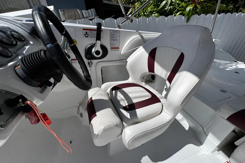 Slide: The Image of Steering area of a 2017 Tahoe 2150 boat with white and maroon seating. - 15