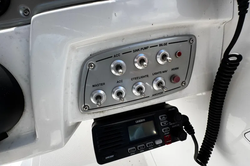 Slide: The Image of Control panel of a 2017 Tahoe 2150 boat with switches and radio. - 21