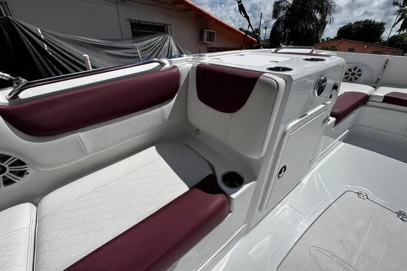 Slide: The Image of 2017 Tahoe 2150 boat interior with maroon and white seating, cup holders, and storage compartments. - 25