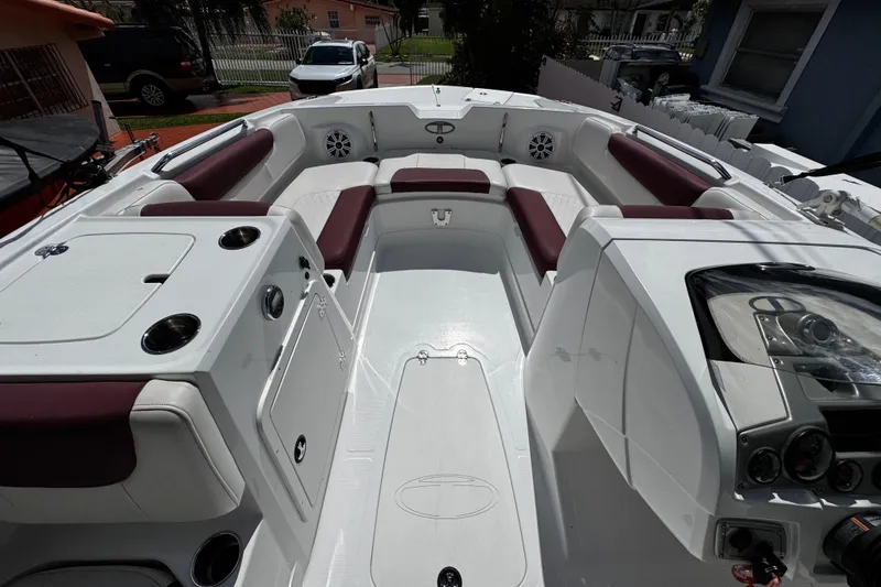 Slide: The Image of 2017 Tahoe 2150 boat interior with white and maroon seating, dashboard, and cup holders. - 26