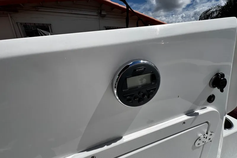 Slide: The Image of 2017 Tahoe 2150 boat dashboard with Jensen audio system under cloudy sky. - 27