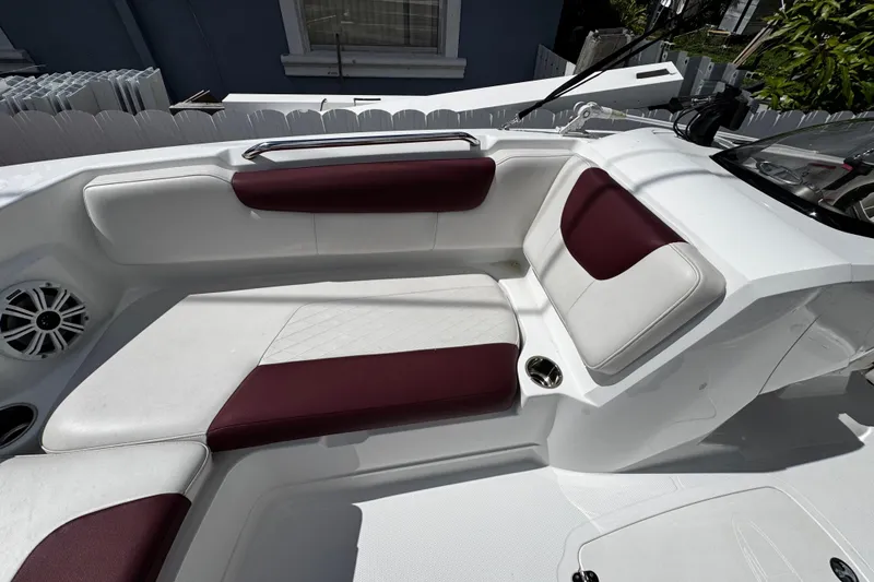 Slide: The Image of 2017 Tahoe 2150 boat interior with white and maroon seating, cup holder, and speaker. - 30