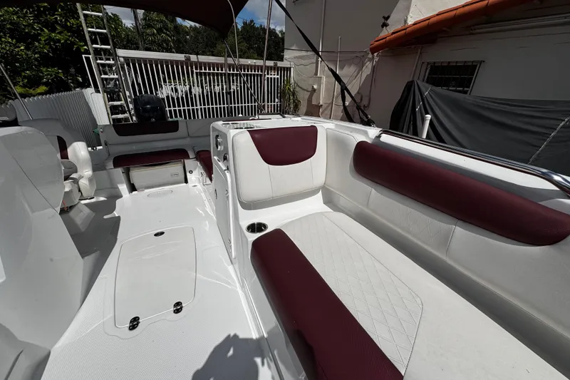 Slide: The Image of 2017 Tahoe 2150 boat interior with white and maroon seating, outdoor setting. - 34