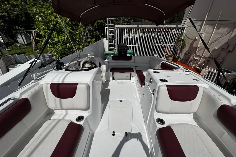 Slide: The Image of 2017 Tahoe 2150 boat interior with maroon and white seating, canopy, and steering console. - 35