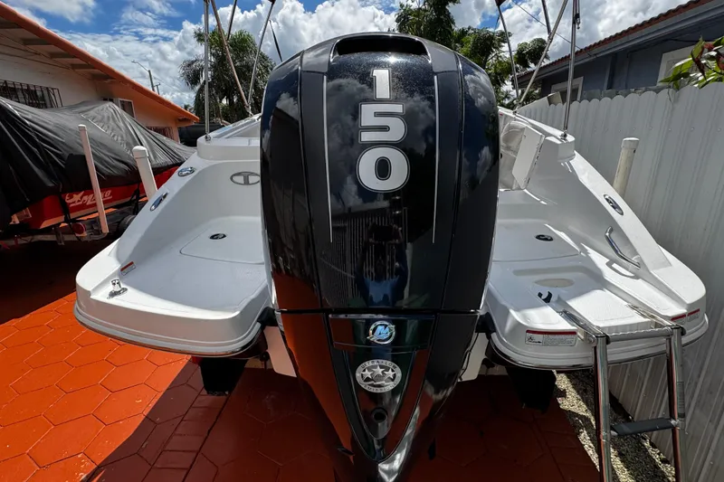 Slide: The Image of 2017 Tahoe 2150 boat with a 150 horsepower Mercury outboard engine, parked outdoors. - 39