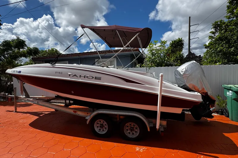 Slide: The Image of 2017 Tahoe 2150 boat on trailer, parked outdoors under a cloudy sky. - 5