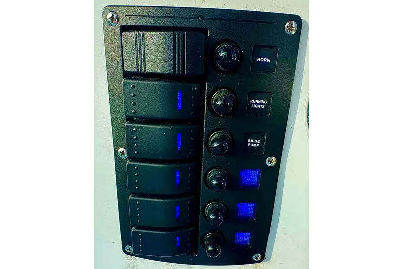 Slide: The Image of Control panel of 2024 Panga 25 CC boat with switches for horn, lights, and bilge pump. - 13