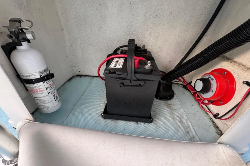 Slide: The Image of Battery and fire extinguisher setup on 2024 Panga 25 CC boat interior. - 14