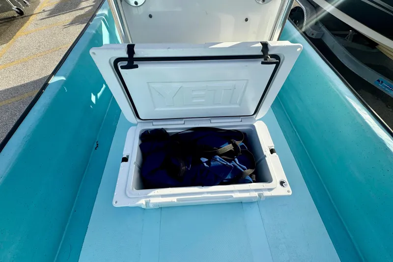 Slide: The Image of Open Yeti cooler on 2024 Panga 25 CC boat, containing a blue bag. - 19