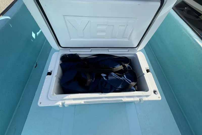 Slide: The Image of Open YETI cooler on 2024 Panga 25 CC boat, containing a blue bag. - 22