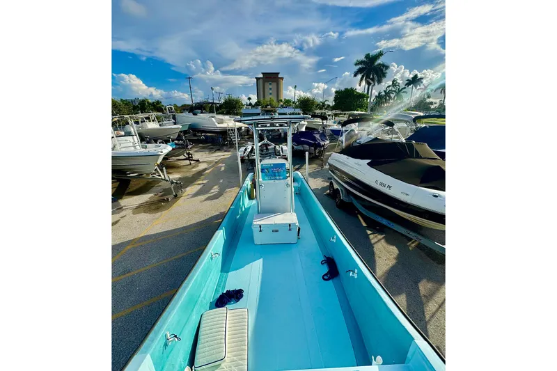 Slide: The Image of 2024 Panga 25 CC boat in a marina, surrounded by other vessels under a sunny sky. - 26