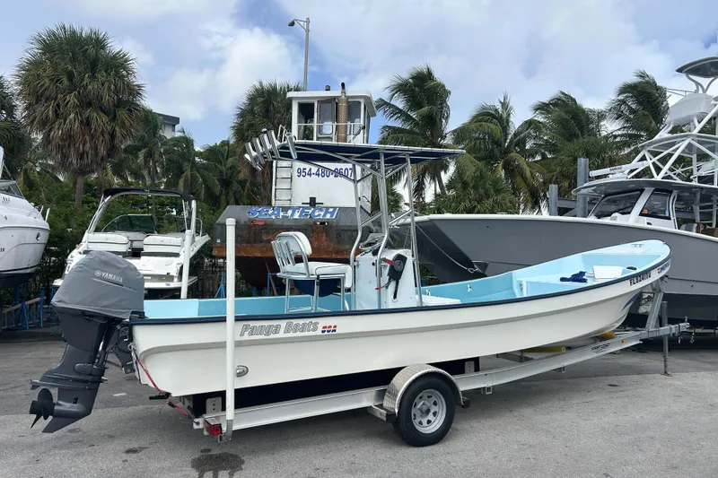 Slide: The Image of 2024 Panga IMEMSA 25 CC boat on trailer, parked near palm trees and other boats. - 27