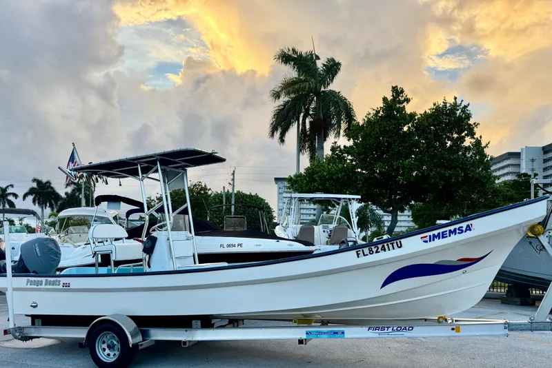 Slide: The Image of 2024 Panga 25 CC boat on trailer, parked with palm trees and sunset sky. - 38