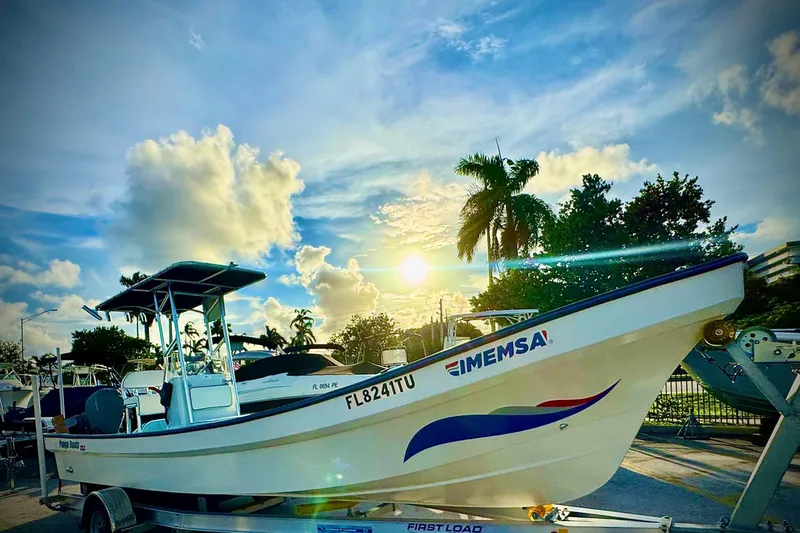 Slide: The Image of 2024 Panga 25 CC boat on trailer, sunny day, palm trees in background. - 39