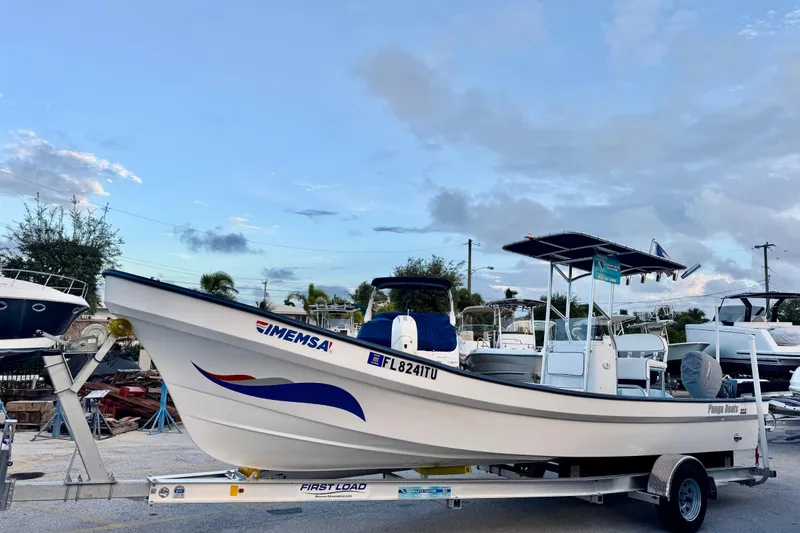 Slide: The Image of 2024 Panga 25 CC boat on trailer, clear sky background, parked in marina. - 4