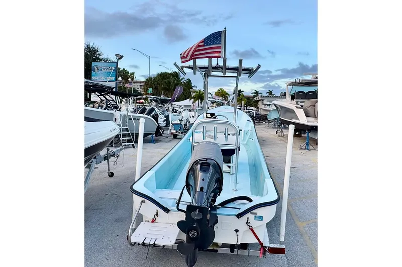 Slide: The Image of 2024 Panga 25 CC boat with American flag, displayed at a marina. - 49