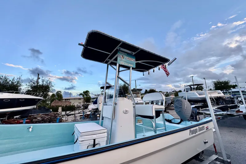 Slide: The Image of 2024 Panga 25 CC boat with T-top, docked under a blue sky. - 5