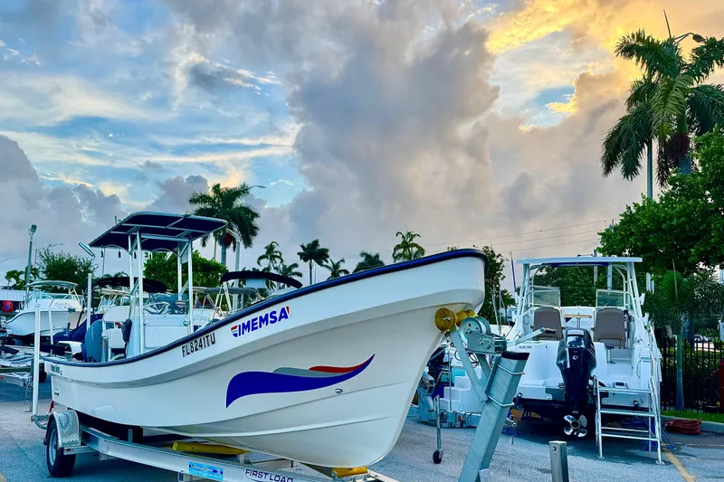 Slide: The Image of 2024 Panga 25 CC boat on trailer, parked under a vibrant sunset sky. - 6