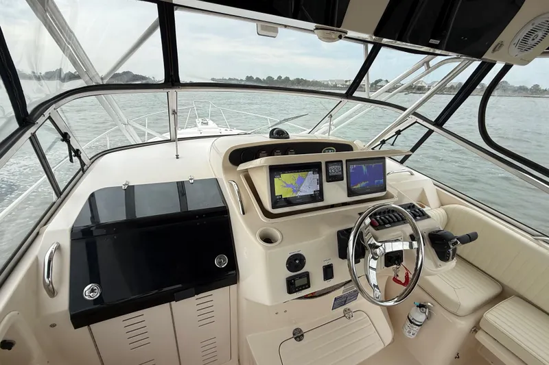 Slide: The Image of 2005 Grady-White Express 330 boat cockpit with navigation screens and steering wheel. - 16