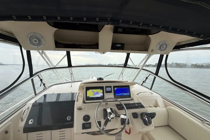 Slide: The Image of 2005 Grady-White Express 330 boat cockpit with navigation screens and steering wheel. - 17