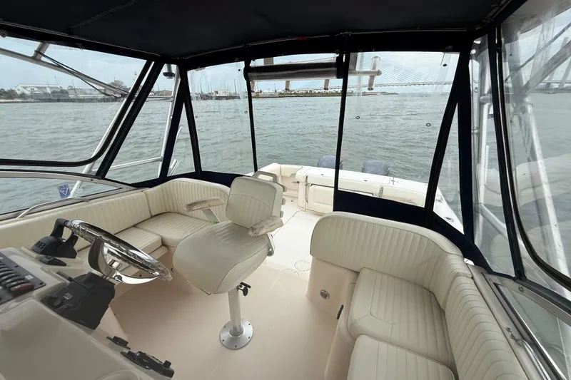 Slide: The Image of 2005 Grady-White Express 330 boat interior with helm and seating, overlooking water and bridge. - 23