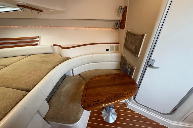 Slide: The Image of 2005 Grady-White Express 330 cabin interior with cushioned seating and wooden table. - 29