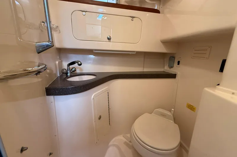 Slide: The Image of 2005 Grady-White Express 330 boat bathroom with sink, toilet, and storage cabinets. - 31