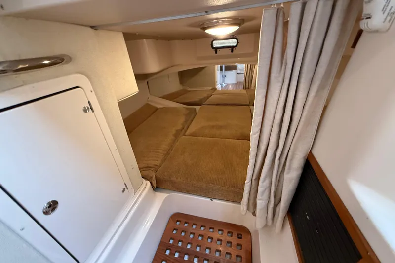 Slide: The Image of 2005 Grady-White Express 330 cabin interior with cozy sleeping area and privacy curtain. - 33
