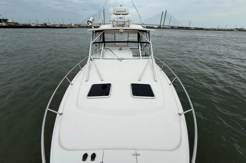 Slide: The Image of 2005 Grady-White Express 330 boat on water, bridge in background, overcast sky. - 38