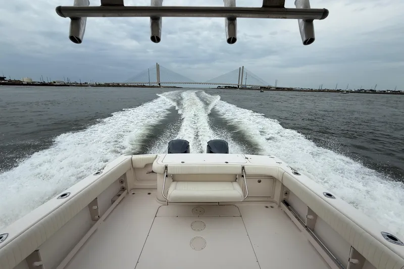 Slide: The Image of 2005 Grady-White Express 330 boat cruising with bridge in background, creating a wake. - 42
