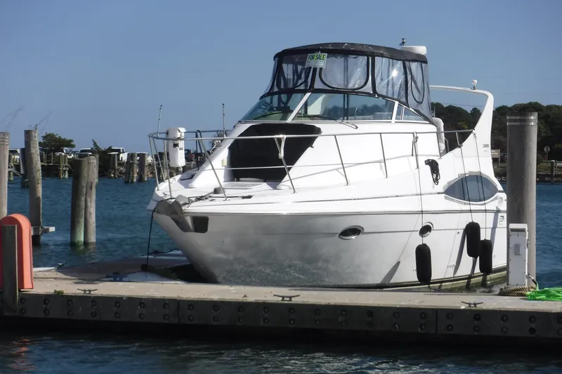 The Image of 2001 Carver 350 Mariner yacht docked, with "For Sale" sign, in a sunny marina setting. - 0