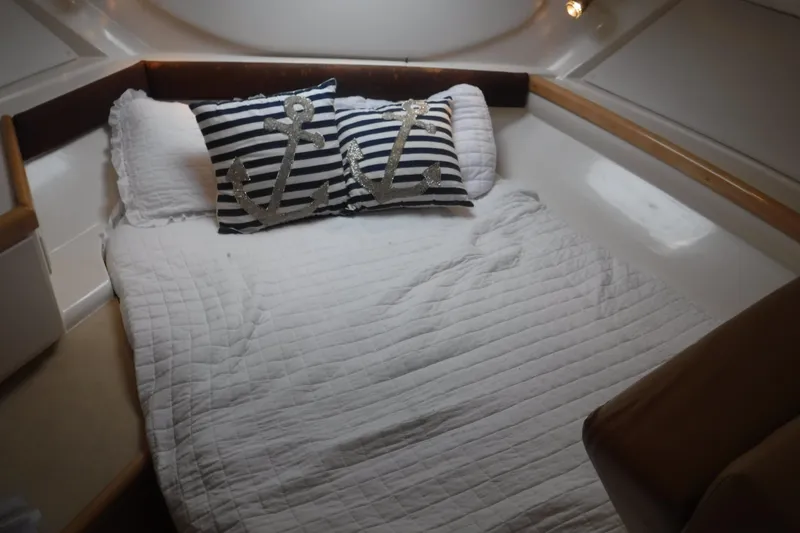 Slide: The Image of Cozy cabin bed in 2001 Carver 350 Mariner with nautical-themed pillows. - 14
